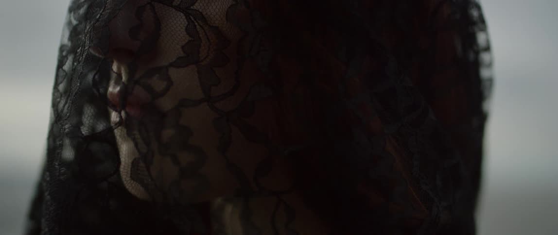 A woman grieves wearing black lace