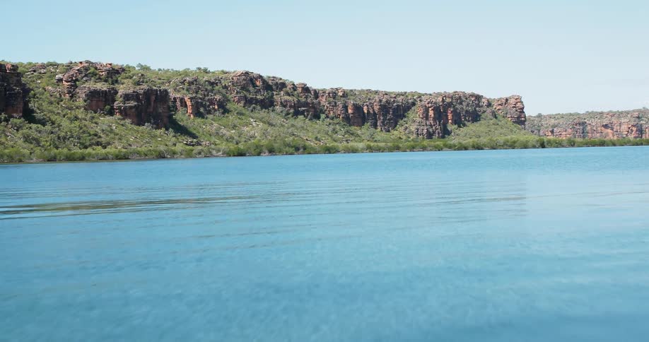 Blue water flows in between cliffs
