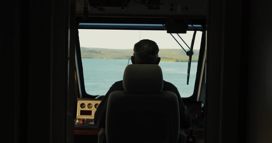A man drives a boat on the water