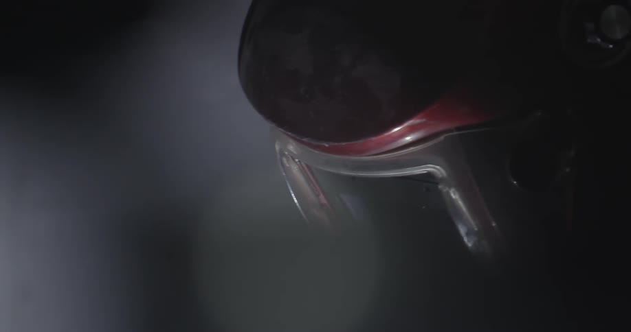 A welder wears a red mask