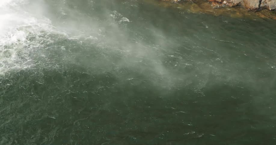 White water sending a spray of mist up a river