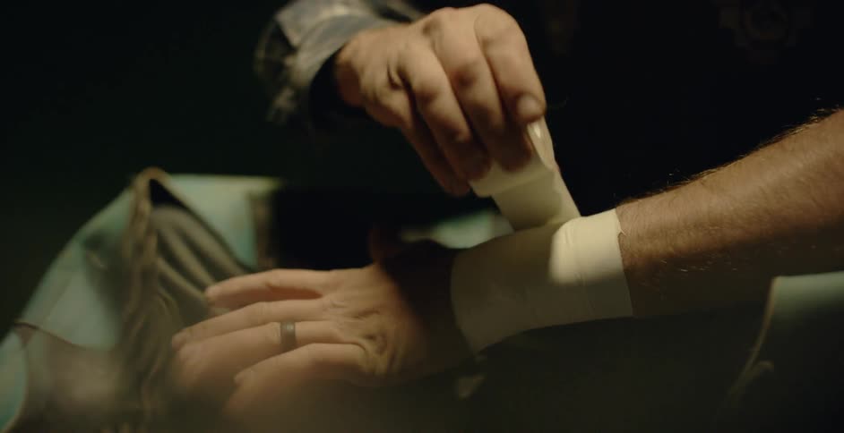A man wraps tape around his left wrist