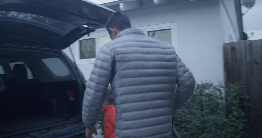 A man and boy carry a box to a car