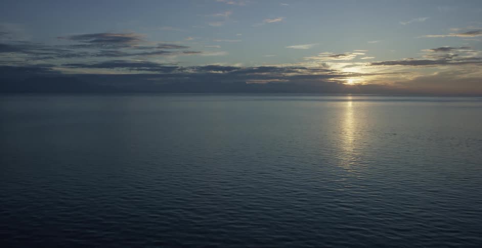 Ocean waters rippling on cloudy evening at sunset