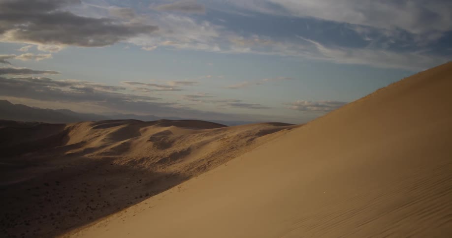 Clouds float over a sandy desert
