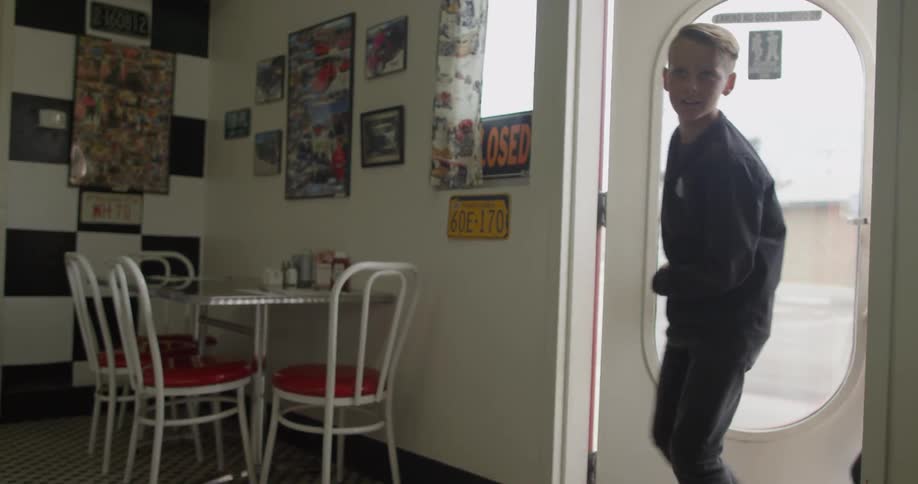 Two boys walking into diner during the day