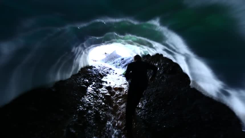 A man walks out of an icy cave