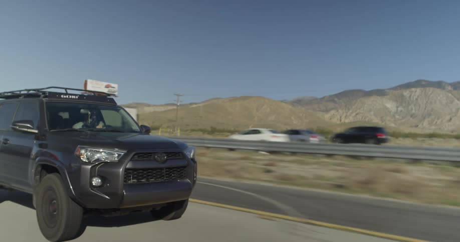 A man drives an suv down a highway