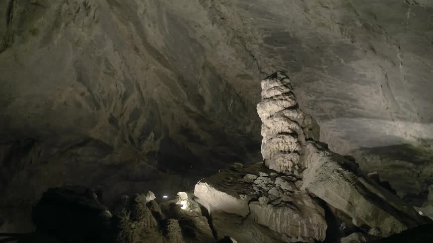 A rock formation stands upright inside a cave