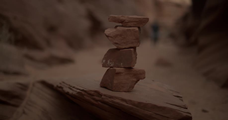 A stack of small rocks sits in a red rock canyon