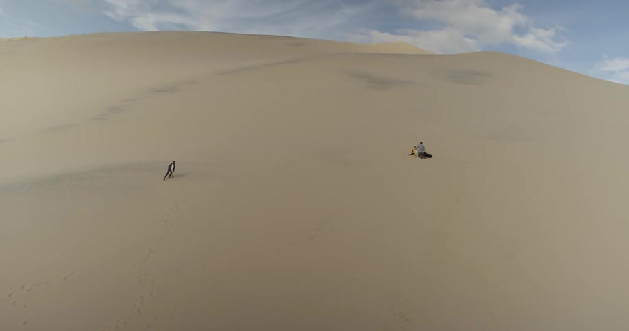 Two people walking in a desert