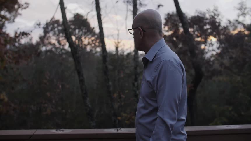 A man is walking looking into the forest