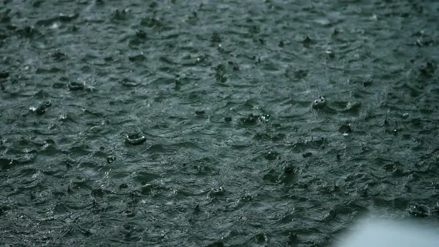 Rain pelting down into a body of water