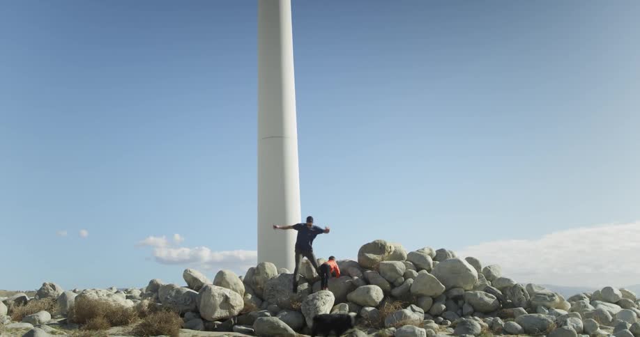A man nearly falls down from atop rocks