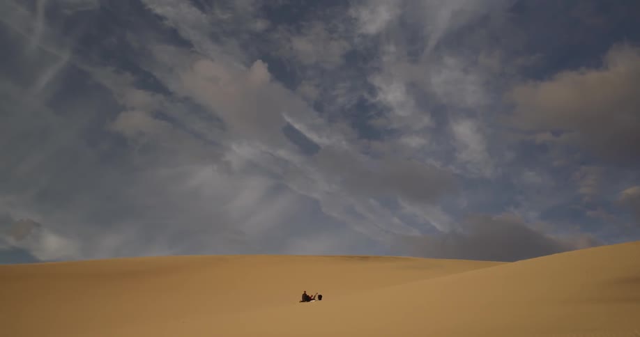 People roll around in a sand dune