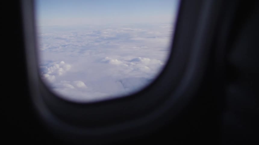 A plane flies above the clouds