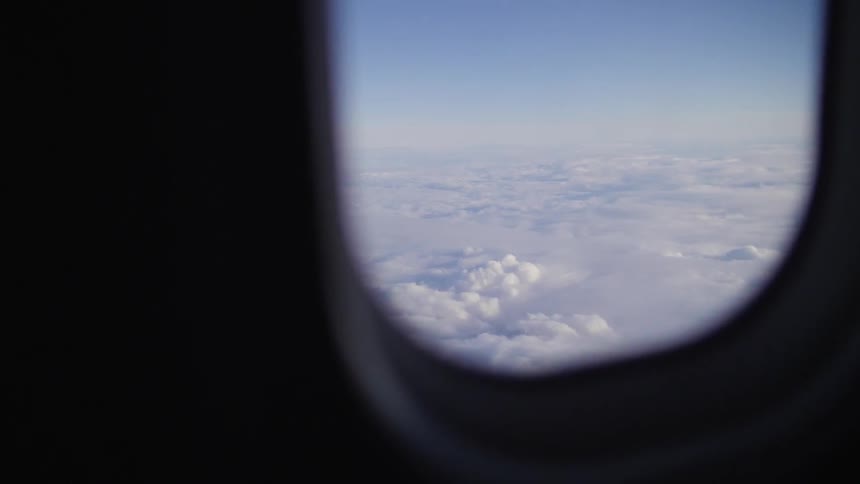 Clouds are seen from an airplane window