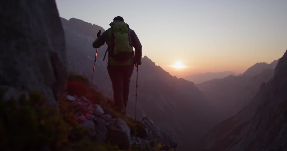 A man hikes alongside a mountain