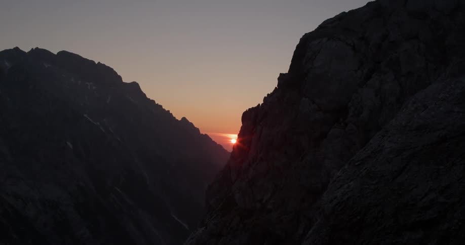 The sun setting between two large mountains
