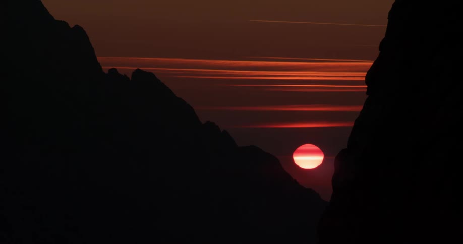 The sun sets over mountains