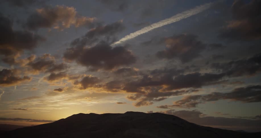 The sun sets over a hill
