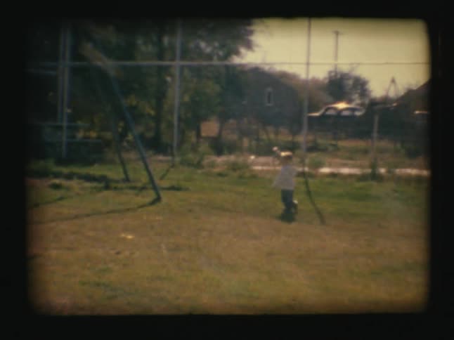 A young boy runs outside in the grass