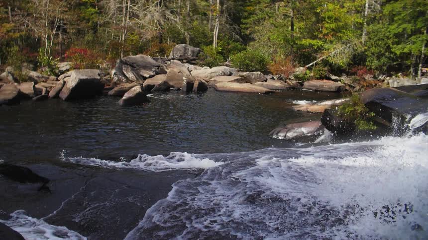 Waterfall splashes with trees in the background