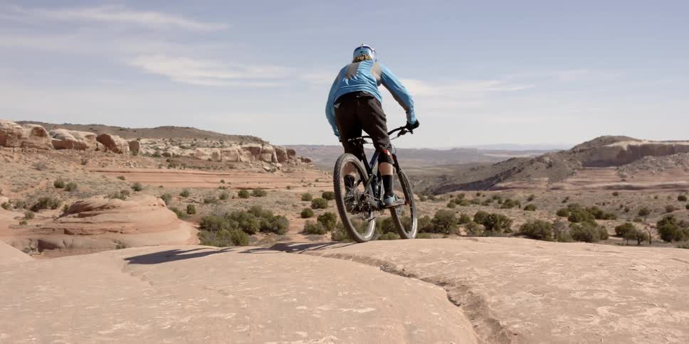 A bicycle rider rides down a cliff