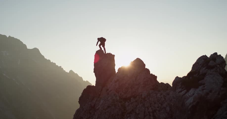 Man climbing up on a cliff on a sunny day