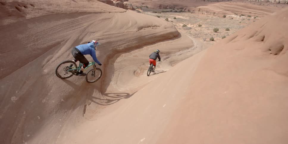 Two people riding bikes through the desert