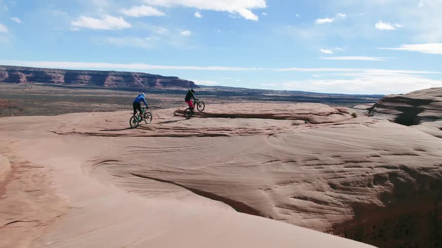 Two people riding bikes through the desert