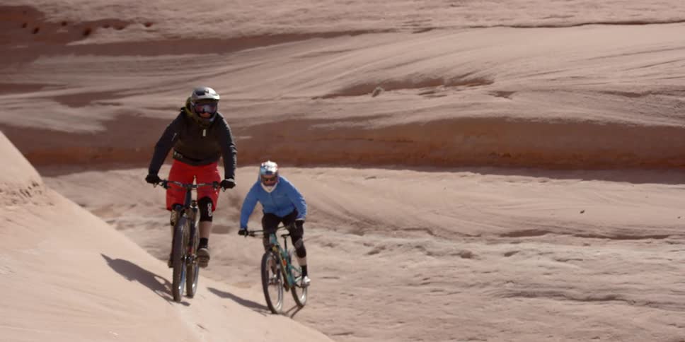 Two people riding bikes through the desert
