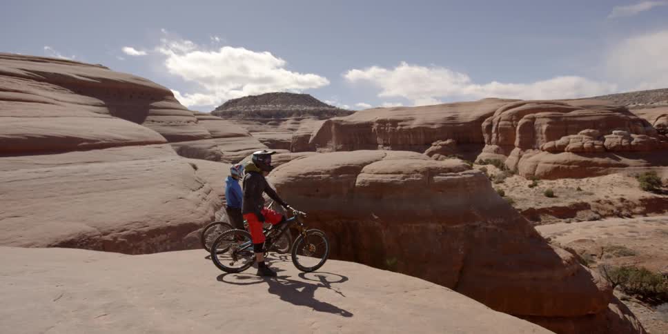Bicyclists ride on rock formations in the desert