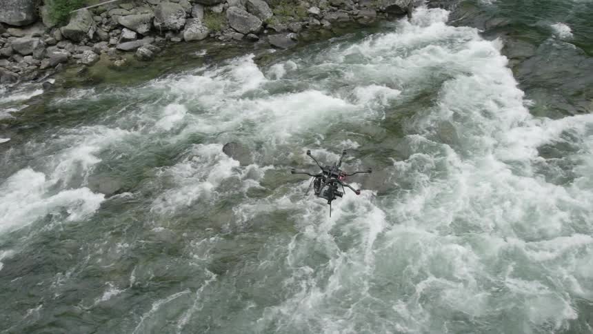 A drone flying over some fast moving rapids