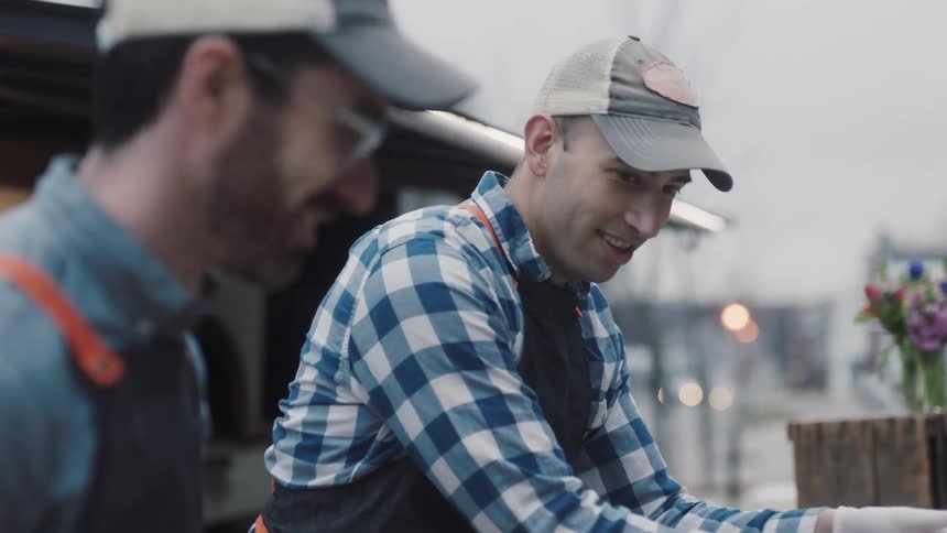 Two men in aprons work outdoors