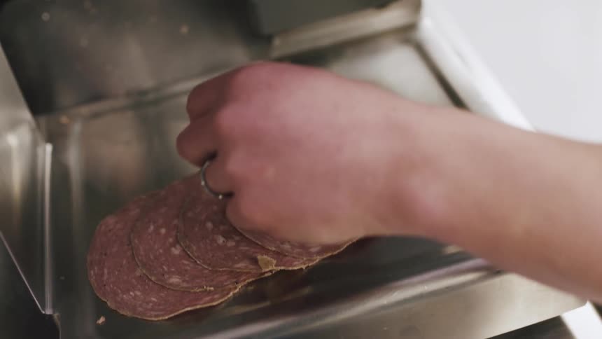Deli meats are sliced in a machine