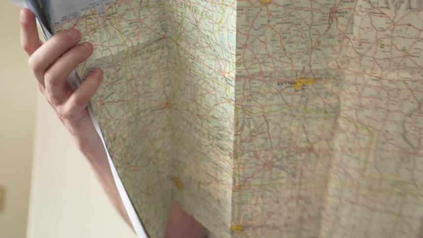 A man is opening and checking a map
