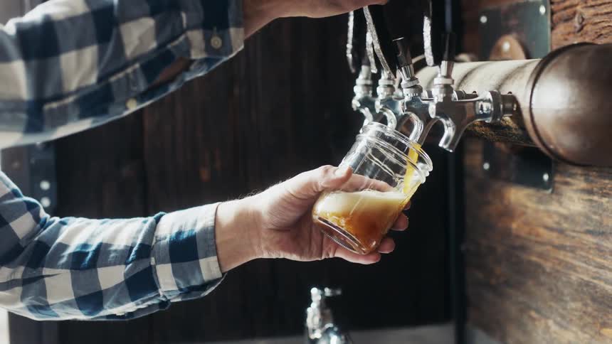 A man fills a glass from faucet