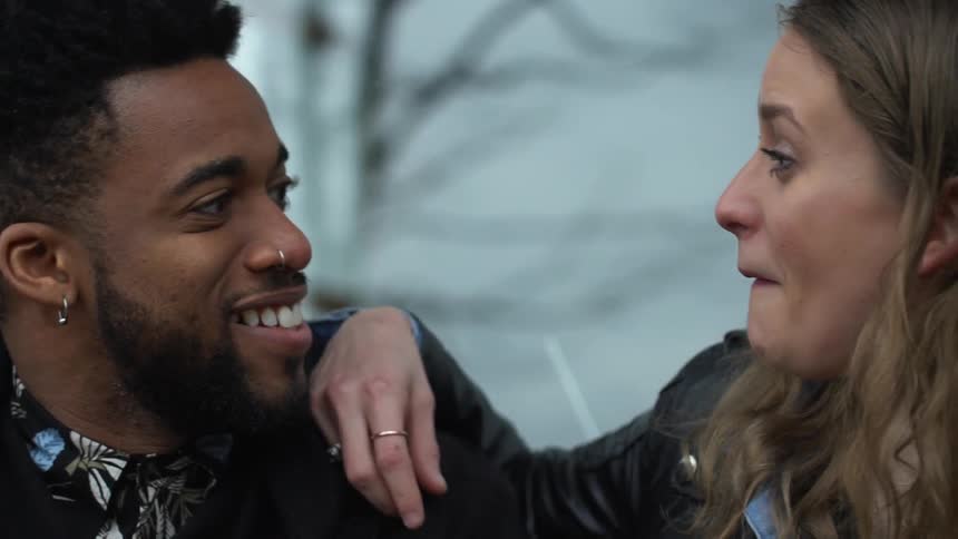 A man and woman converse outside