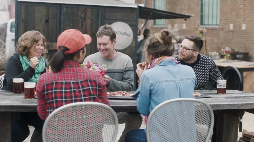 A group of people eat at a picnic table