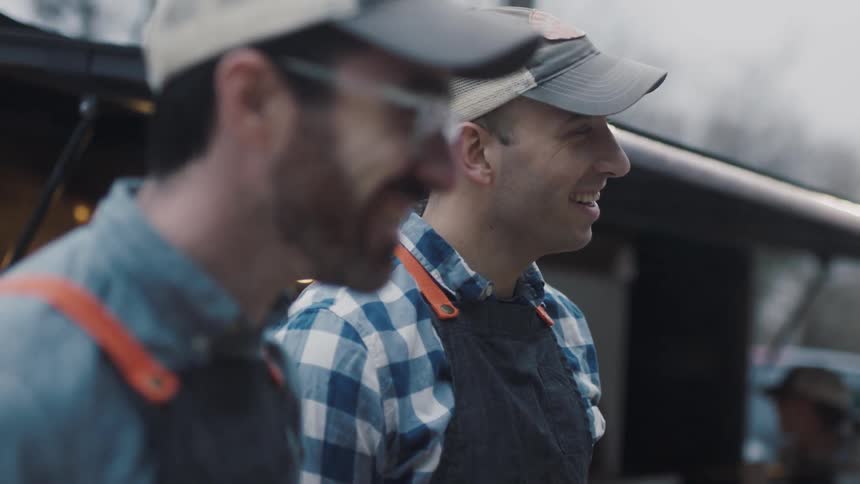 Two men smile while talking