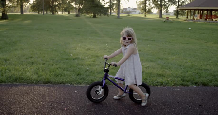 A young girl rides a small bicycle