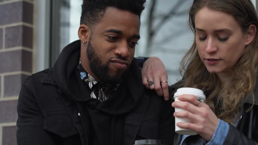 A man and woman talk and drink coffee