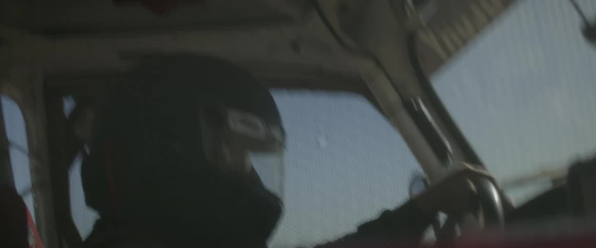 Race car driver holds the steering wheel in his vehicle