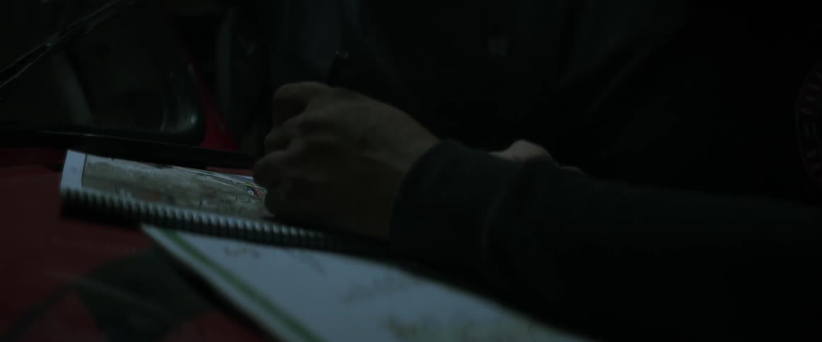 A man is drawing on a notebook