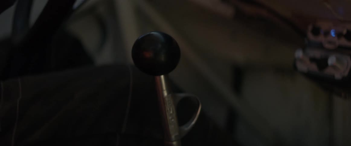 A race driver uses a stick shift as he drives
