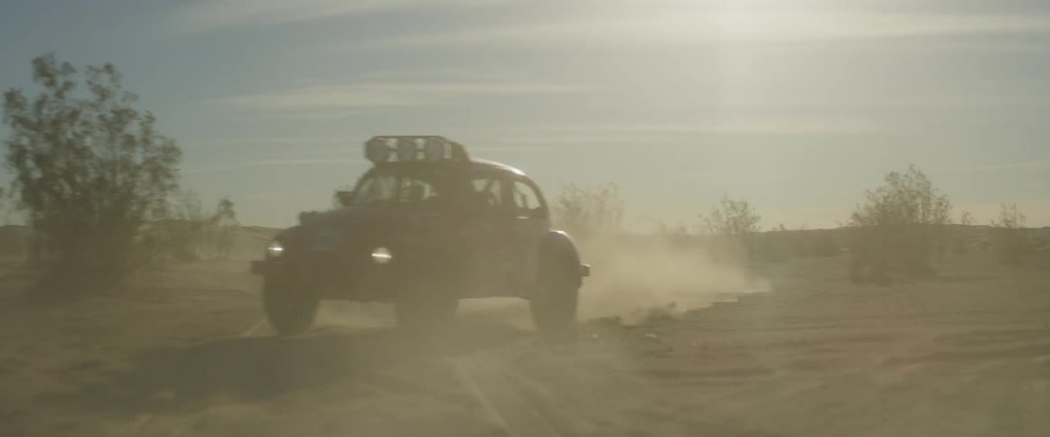 A rally car drives through the desert