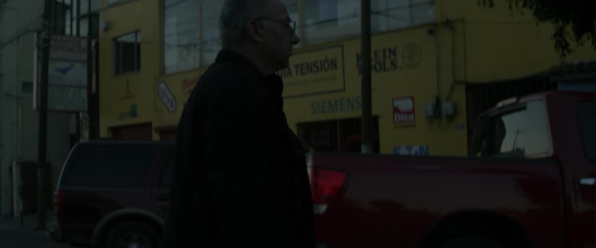A man is walking through a parking lot