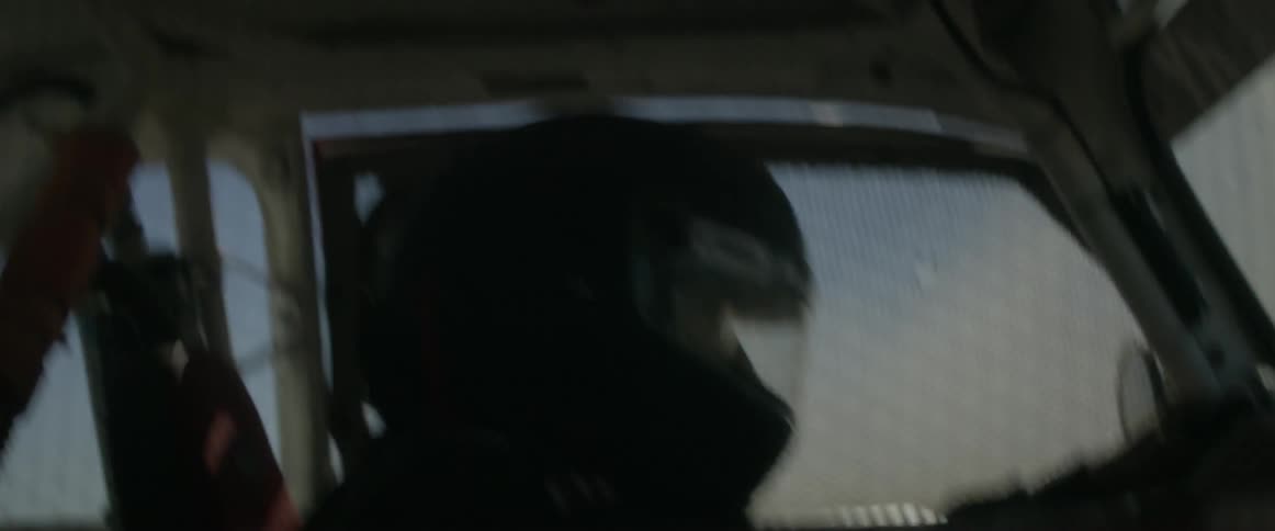 A man is racing a car wearing a helmet