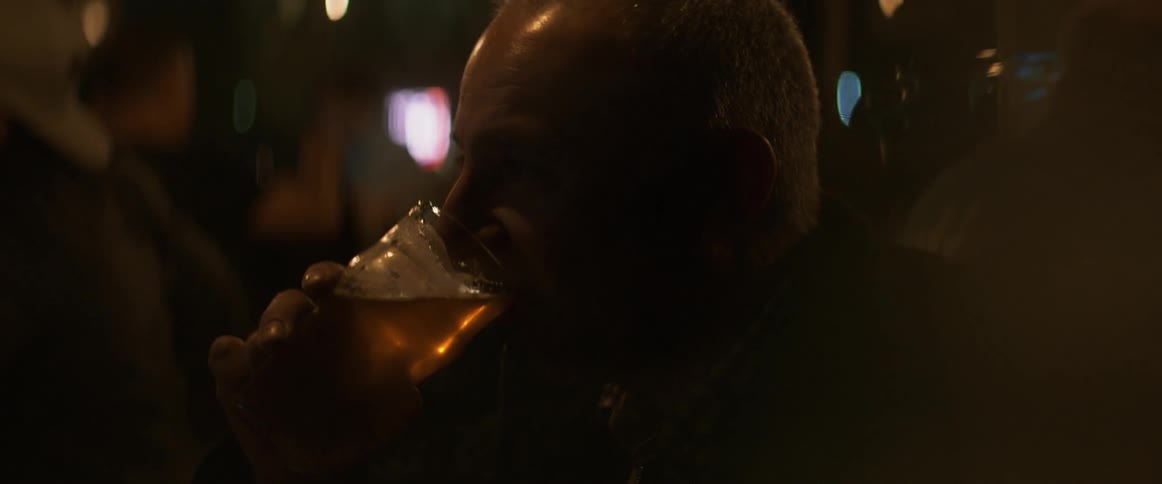 A man takes a drink from a beer